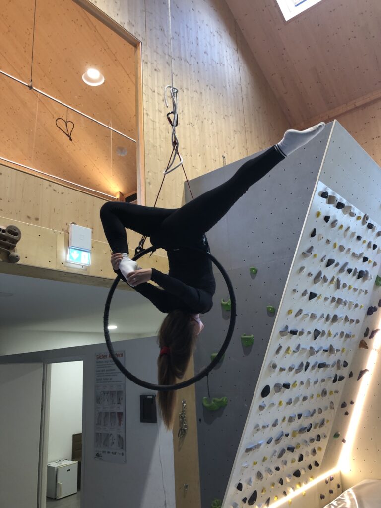 Figur kopfüber im Aerial Hoop in der Kletterhalle
