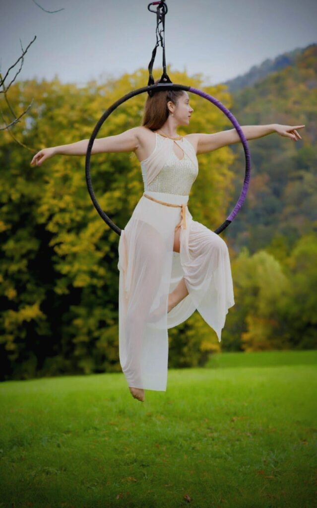 Aerial-Hoop-Figur im Freien vor grüner Wiese